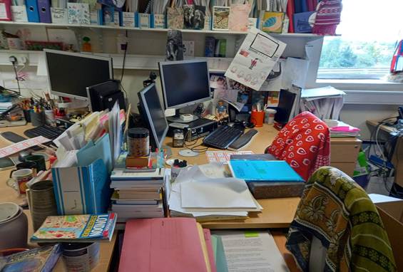 A cluttered desk with multiple computers and books
AI-generated content may be incorrect.