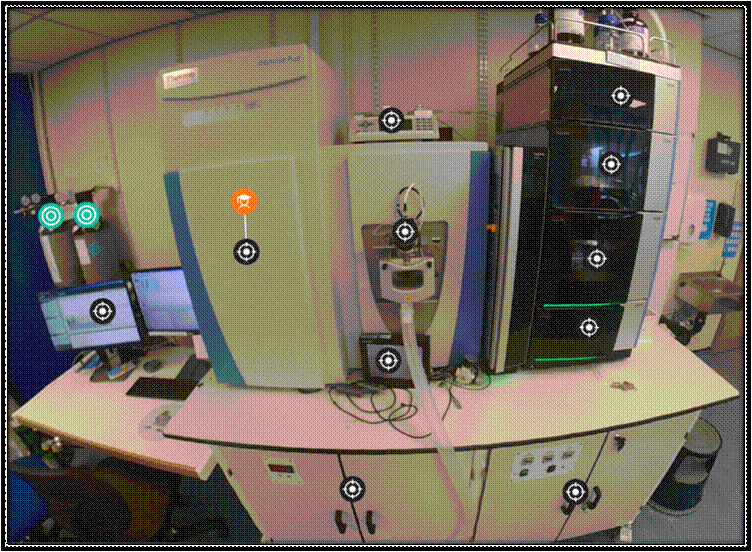 Photograph of mass spectrometry equipment in the lab, with interactive hotspots overlaid.